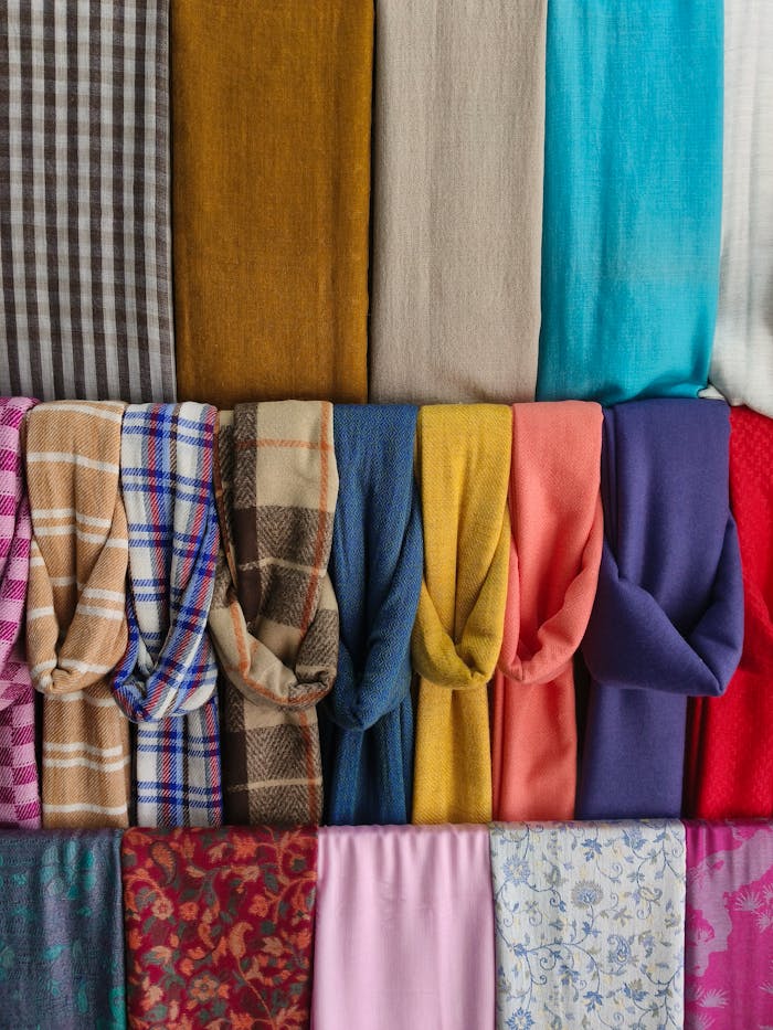 services-03 Vibrant array of folded textiles showcasing diverse patterns and colors in Pokhara, Nepal.