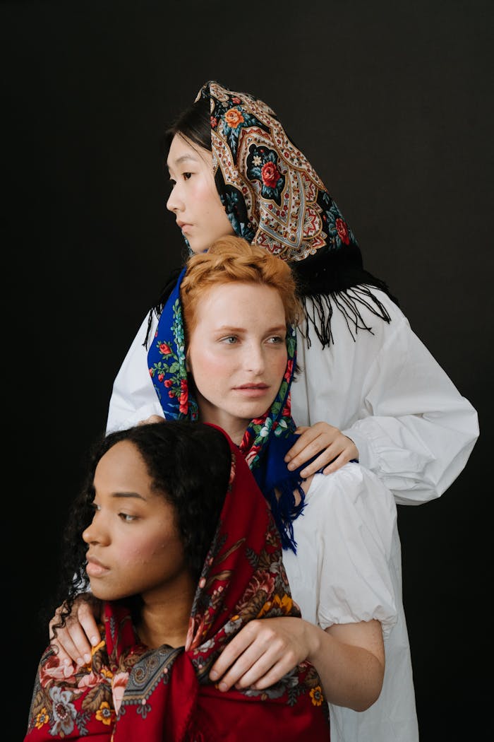 gallery-6 Three women of diverse backgrounds in traditional headscarves, showcasing cultural beauty.